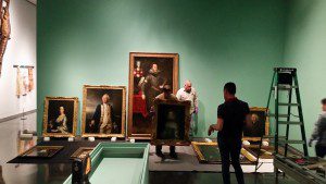 Guest curator William Rudolph works on installing the exhibition's portrait gallery with his crew.