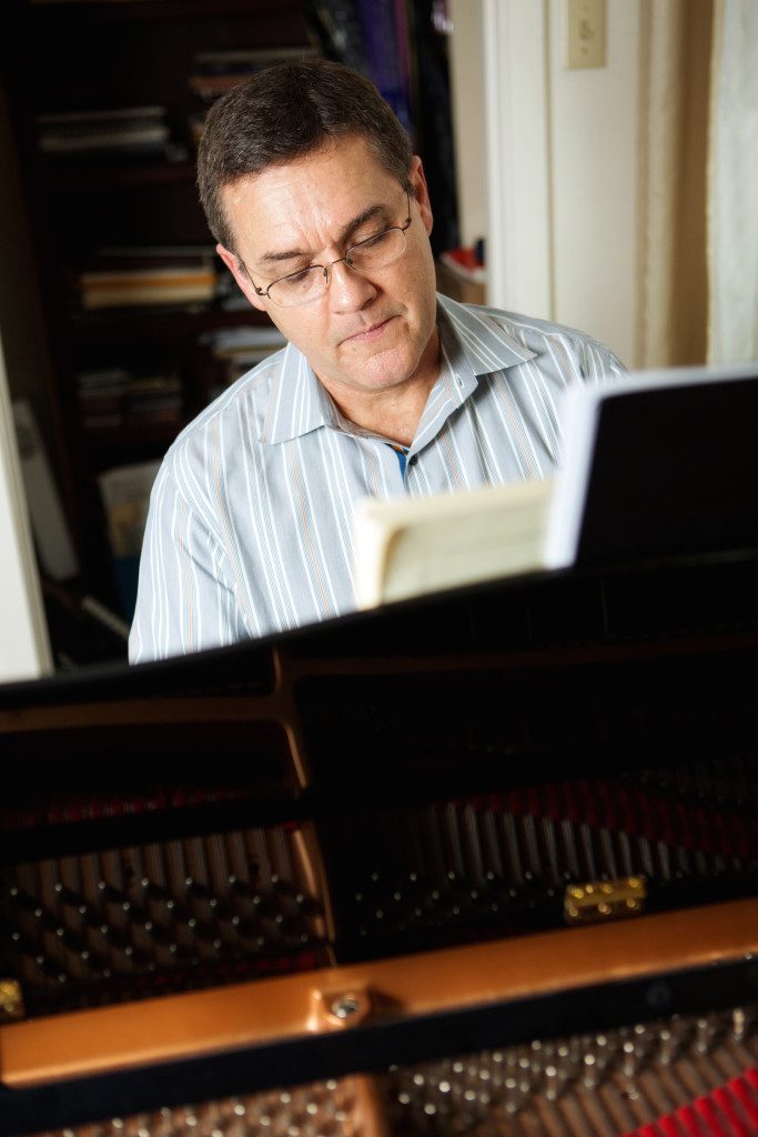 Willis Delony plays the piano at his home. Photo by Collin Richie.