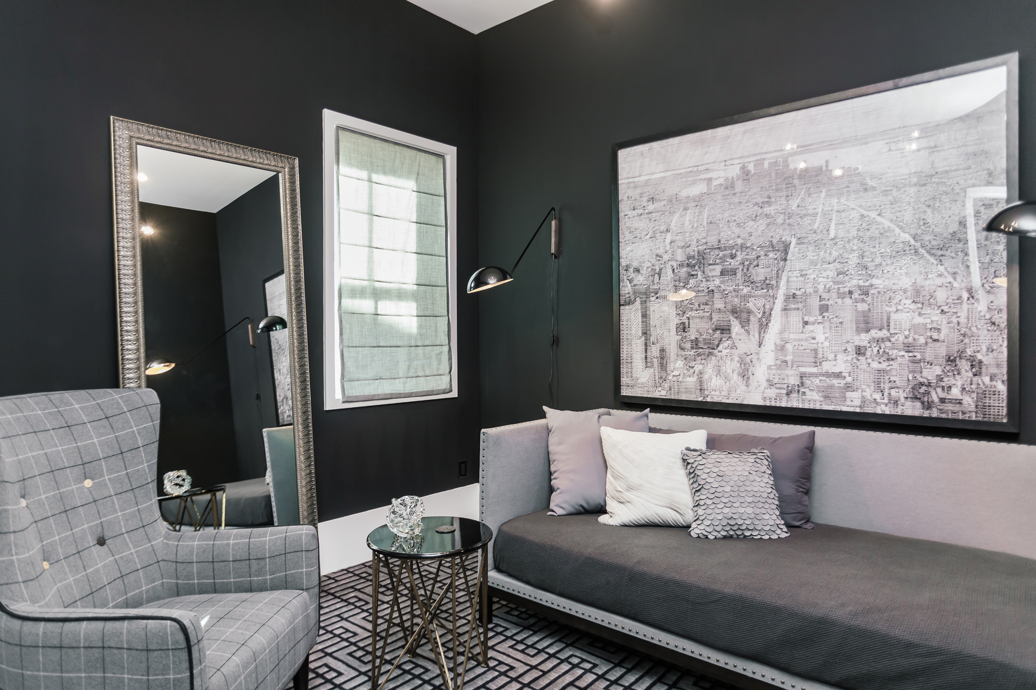 The dark walls of the study are painted in Sherwin Williams’ “Tricorn Black.” A flannel-covered daybed, a patterned carpet and even an ink drawing of one of Jason’s favorite destinations—New York City—are in keeping with the monochromatic palette.