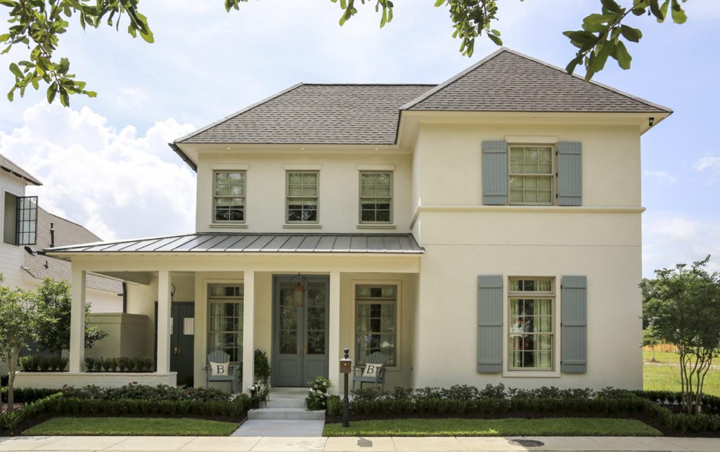 A multi-layered planting scheme by Makaira Landscape complements the cool blue-gray hue of doors and shutters. The deep porch has its own separate entrance to the private side courtyard.