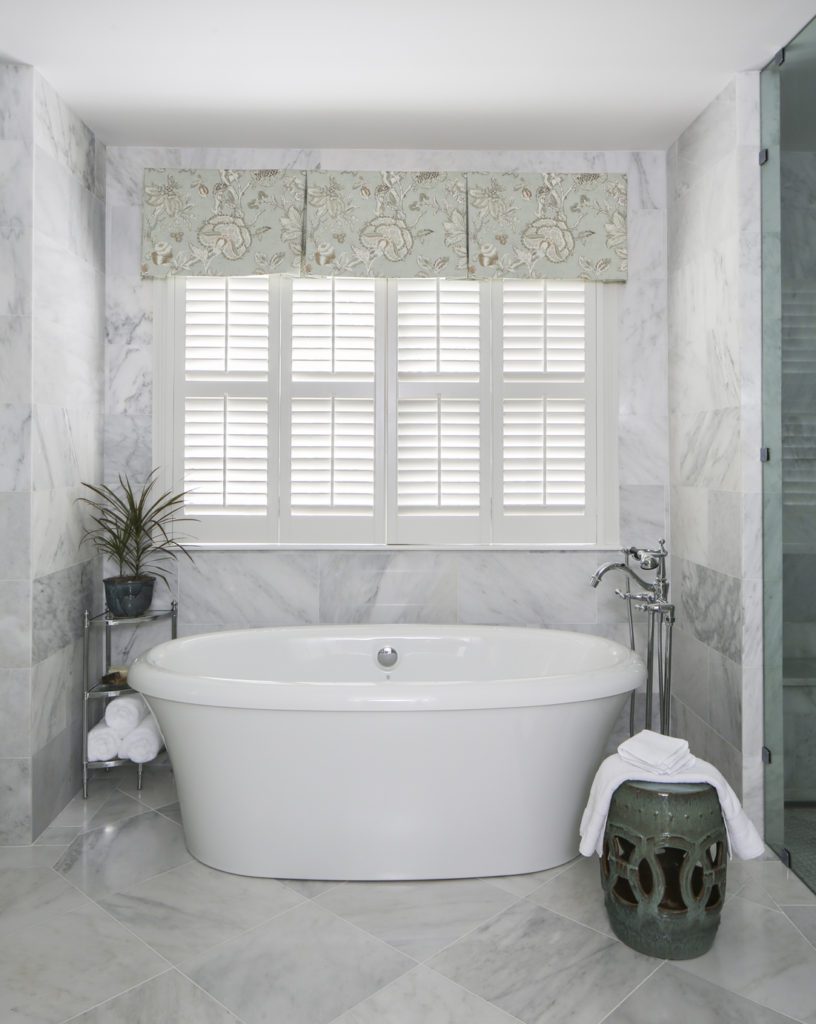 The already spacious master bath was updated with floor-to-ceiling First Snow marble around the new freestanding tub. Photo by Melissa Oivanki.