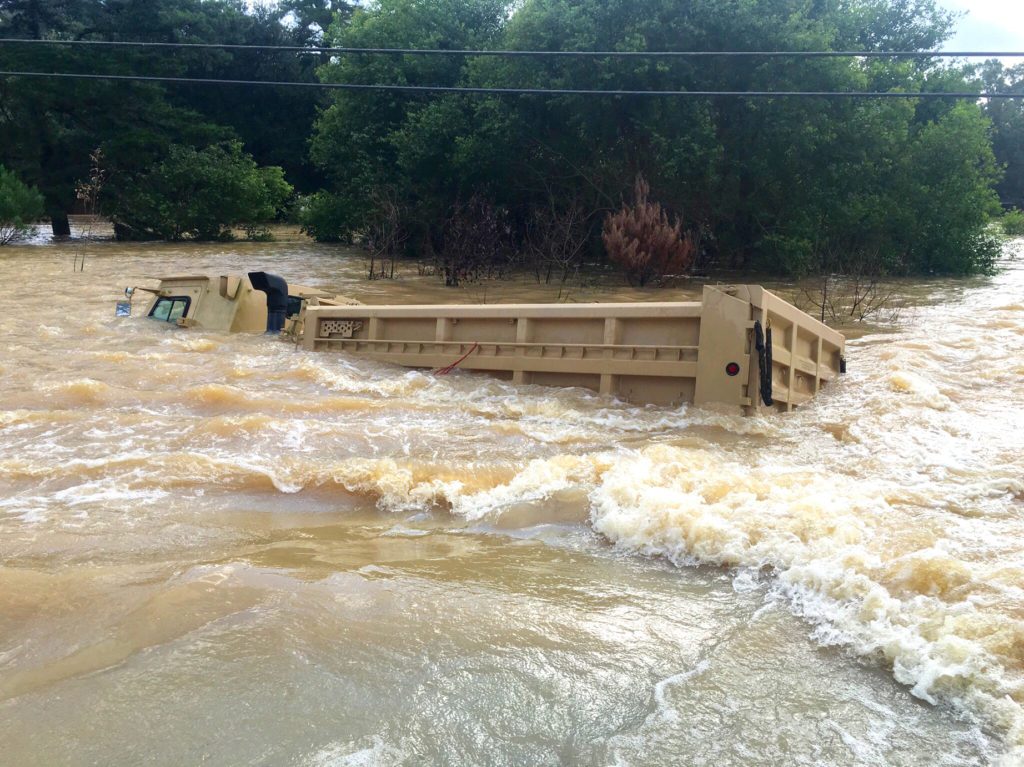 As the Huffstetlers rode along vacated streets in a boat, they saw many sights such as this: an oversize military truck capsized by the rushing waters.