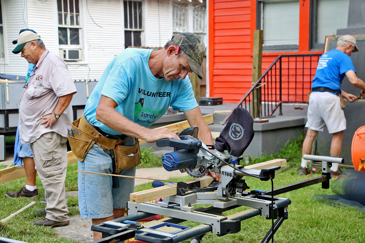 A Silver Hammers volunteer saws wood to help build handicap-accessible ramps at a Fairfields Avenue home. Photo by Matt Deville.