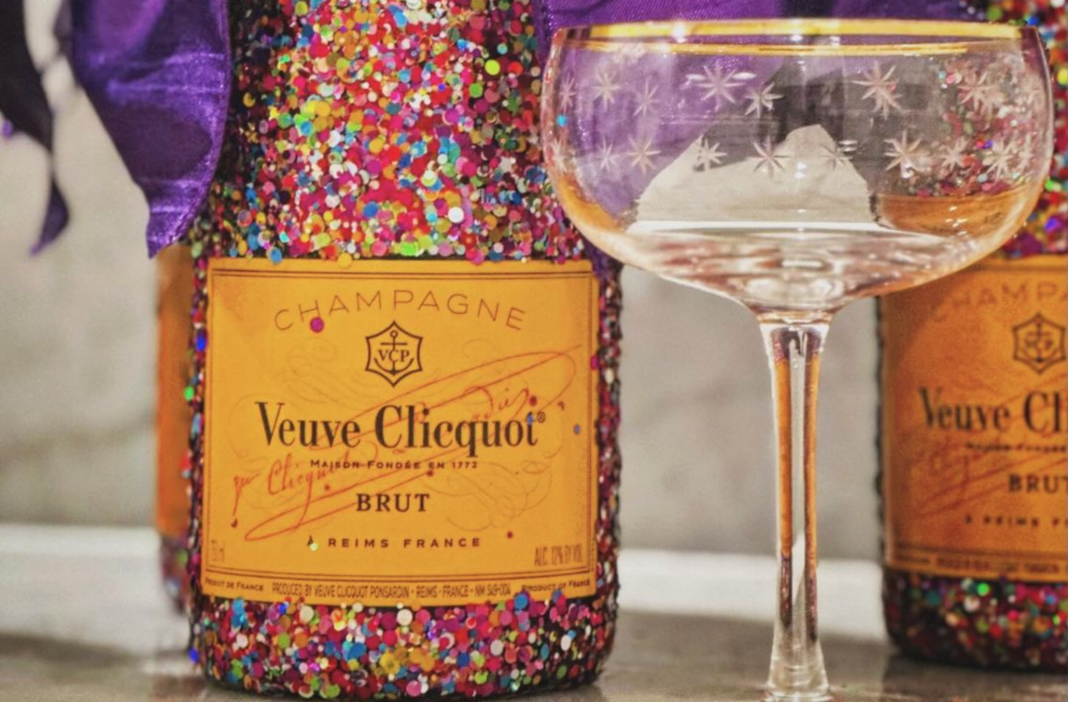 Glitter Veuve Clicquot Bottles from Turning Tables next to a gold rimmed coupe glass
