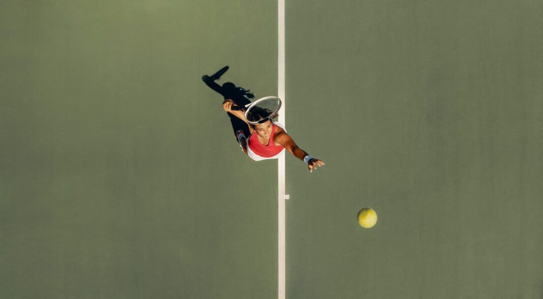 Top view of a woman serving in a tennis match, showcasing her athletic skill and precision