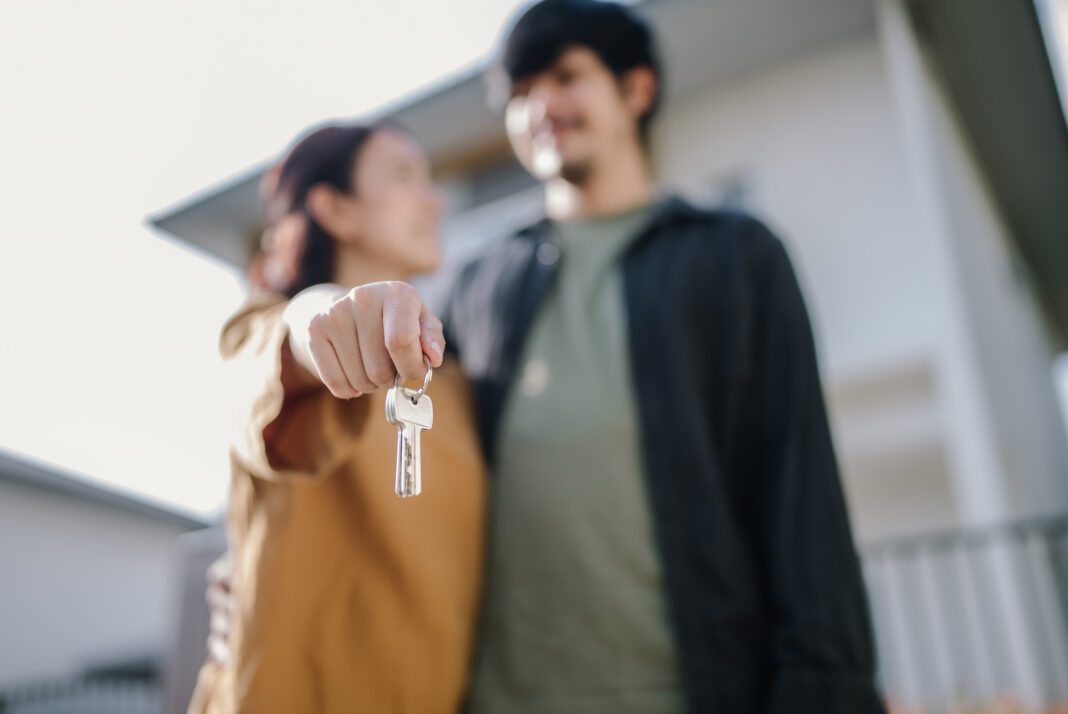 Couple holding house keys.
